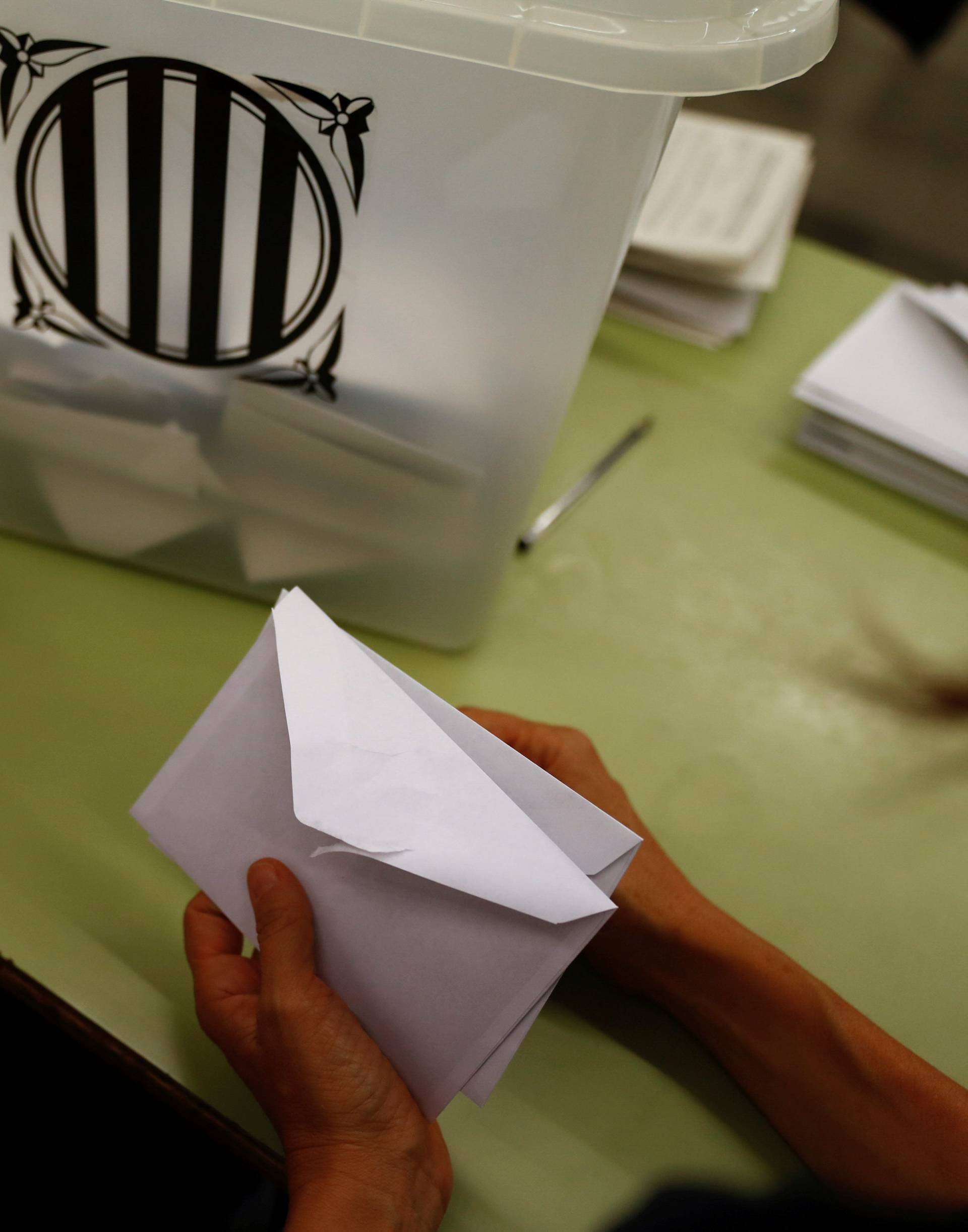 Poll workers count ballots after polls closed at a polling station for the banned independence referendum in Barcelona