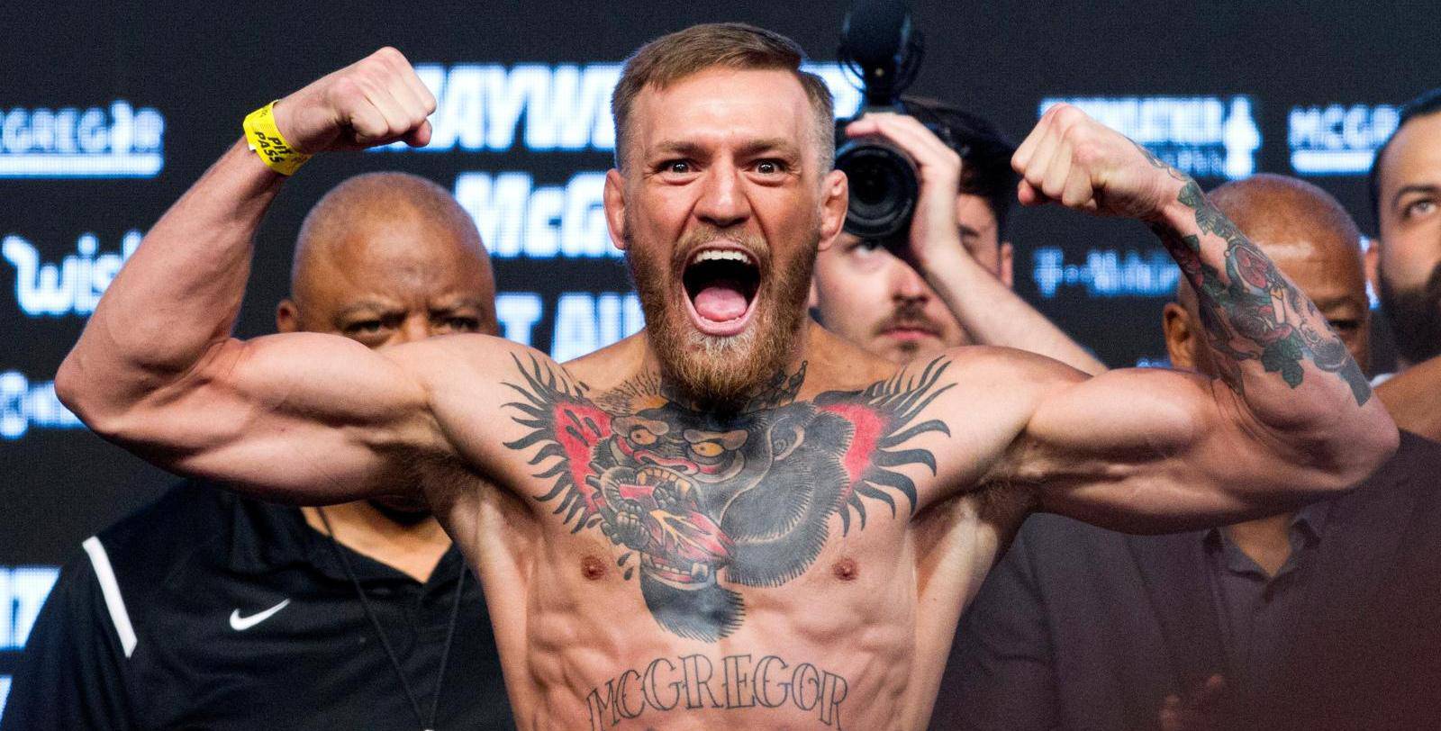 FILE PHOTO: UFC lightweight champion Conor McGregor of Ireland poses on the scale during his official weigh-in at T-Mobile Arena in Las Vegas