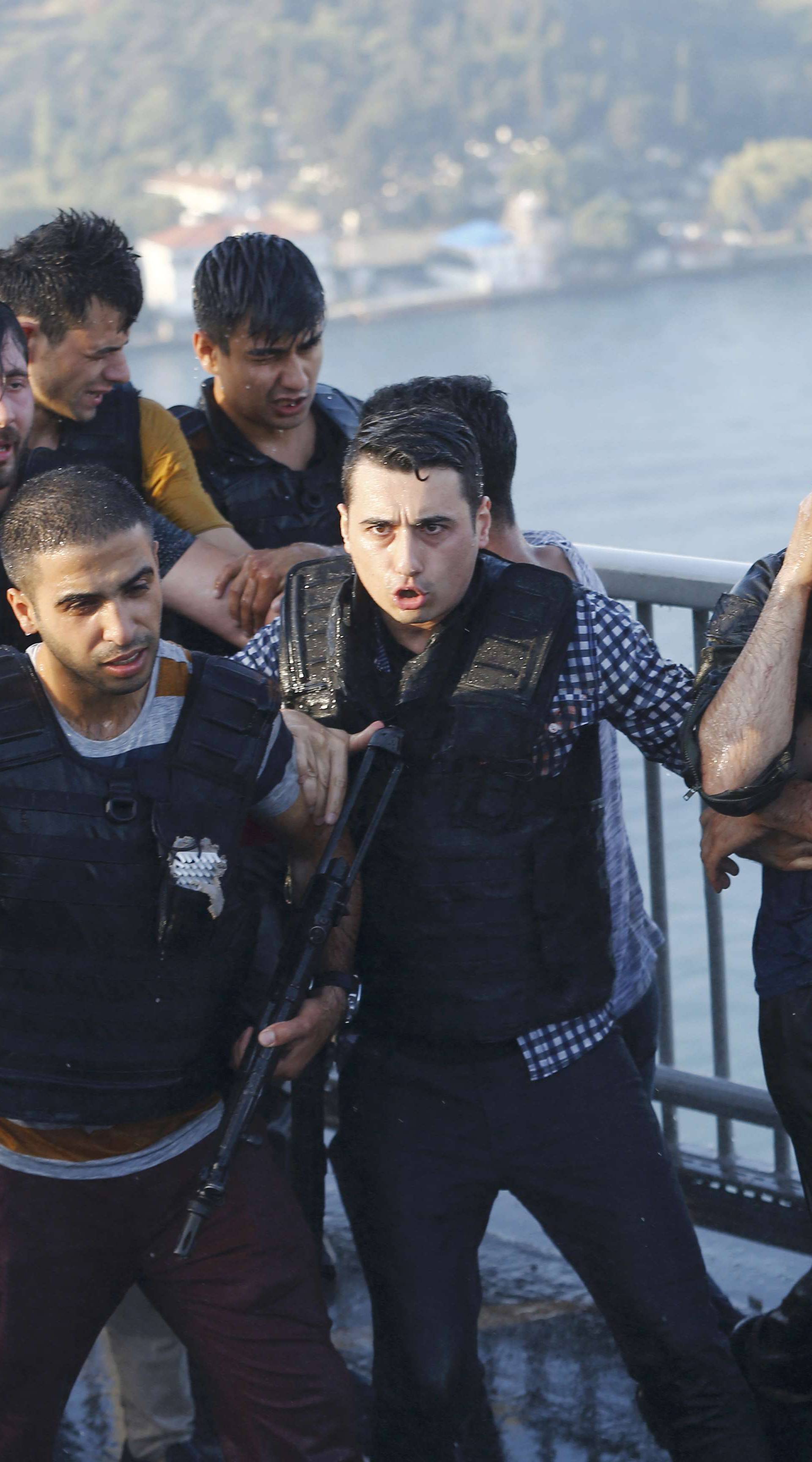 Policemen protect a soldier from the mob after troops involved in the coup surrendered on the Bosphorus Bridge in Istanbul