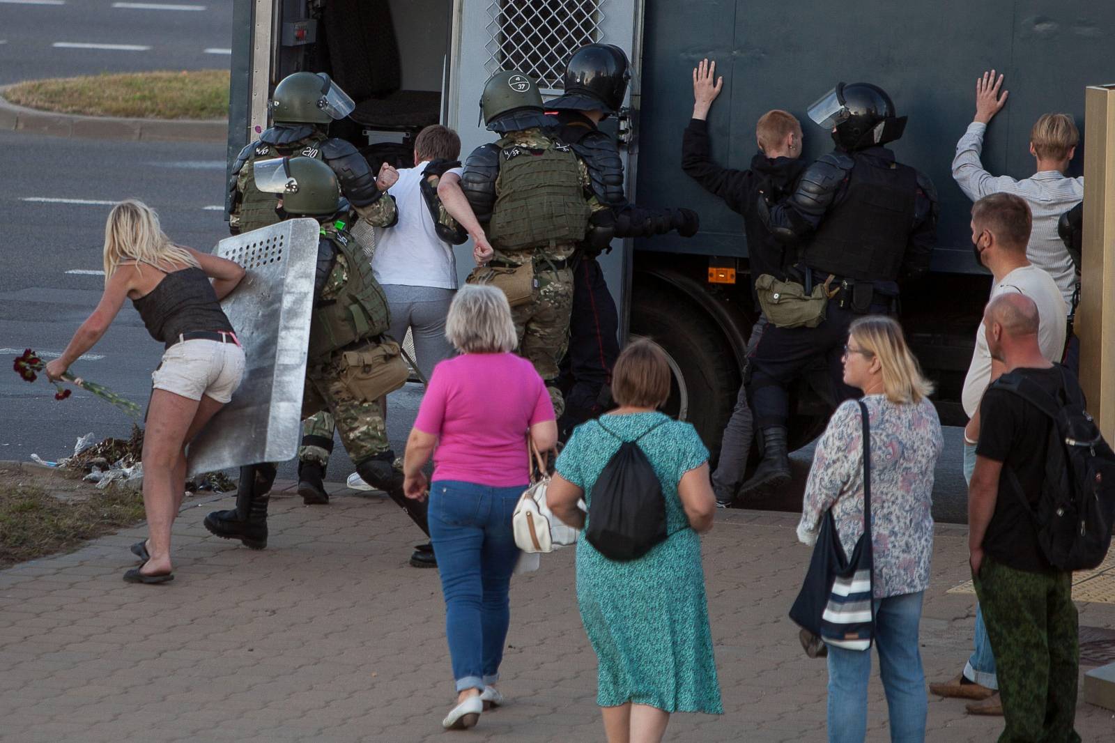 Law enforcement officers detain people near the site where a protester died during a rally following the presidential election in Minsk