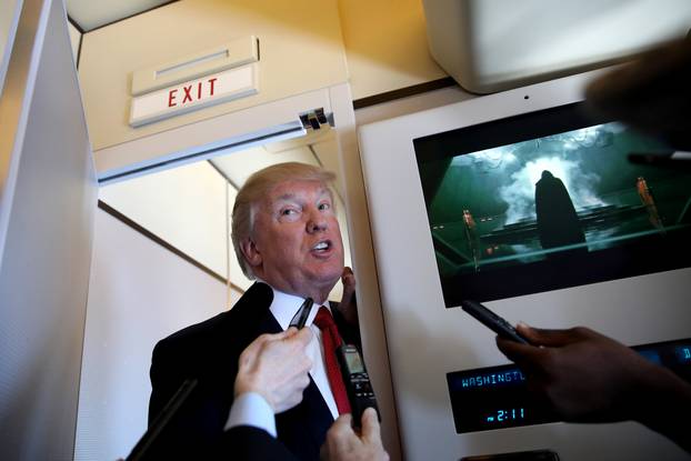 U.S. President Donald Trump talks to journalists, members of the travel pool, on board of Air Force One during his trip to Palm Beach