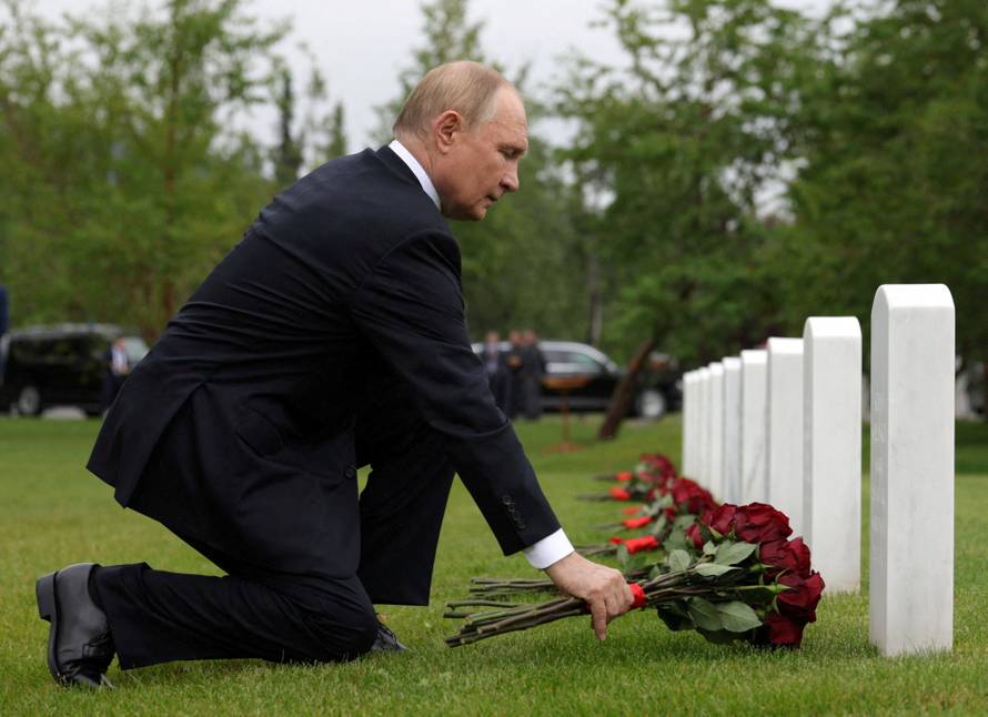 Russian President Vladimir Putin lays flowers at the graves of Soviet soldiers at Fort Richardson National Cemetery near Anchorage