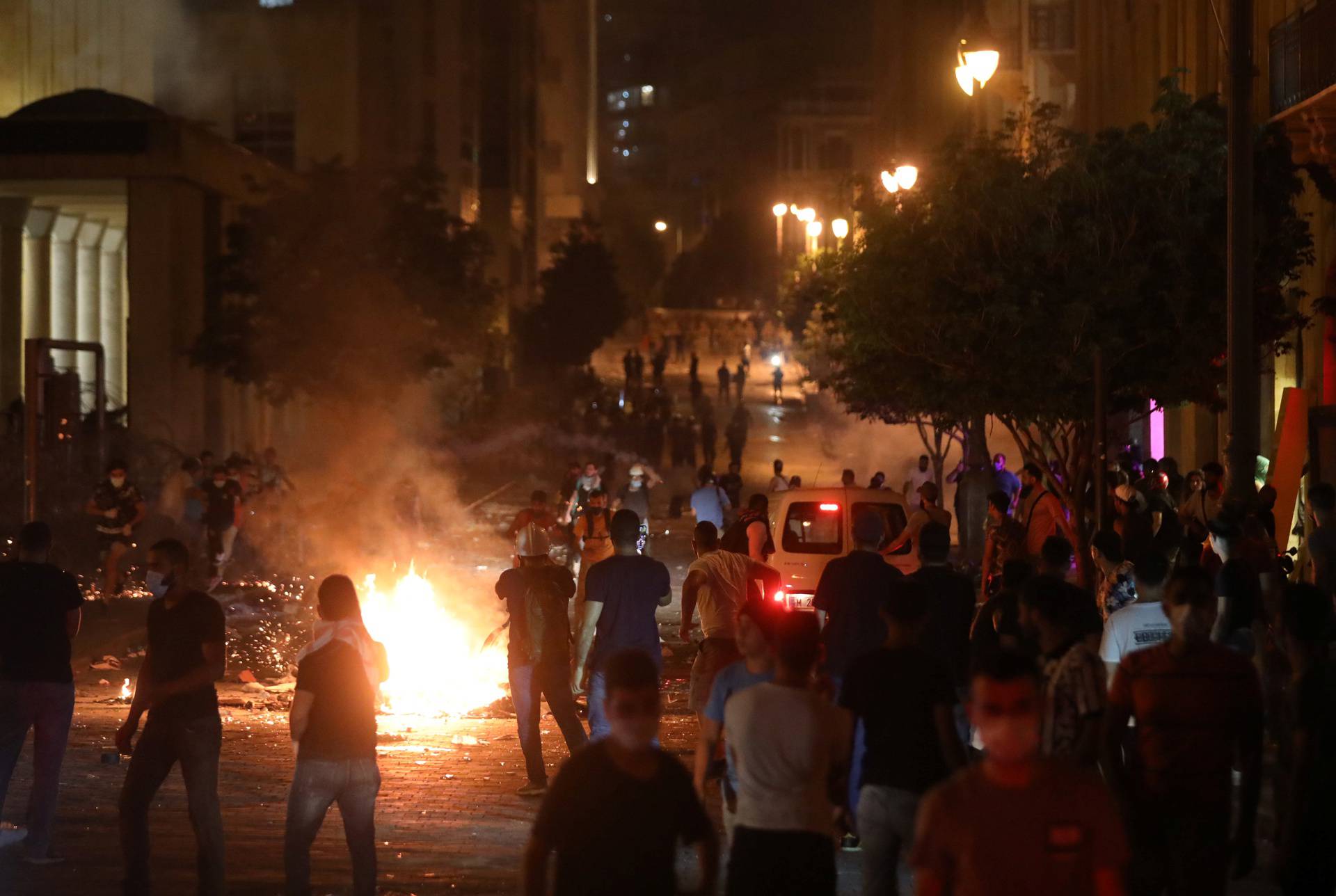 Demonstrators stand near burning fire during a protest near parliament in Beirut
