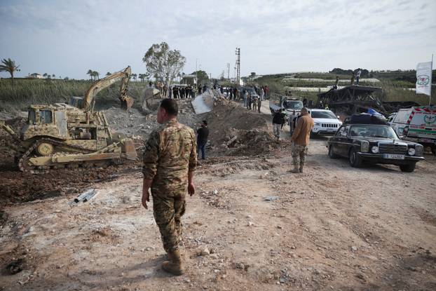 Displaced people cross the bridge linking southern Lebanon to the rest of the country, which was hit earlier in an Israeli strike, in Qasmiyeh