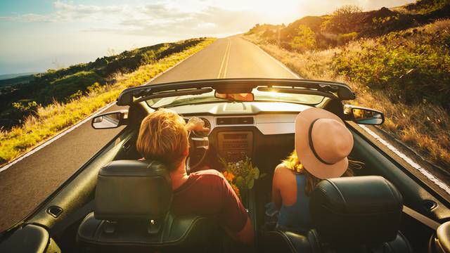 Happy,Young,Couple,Driving,Along,Country,Road,In,Convertible,At