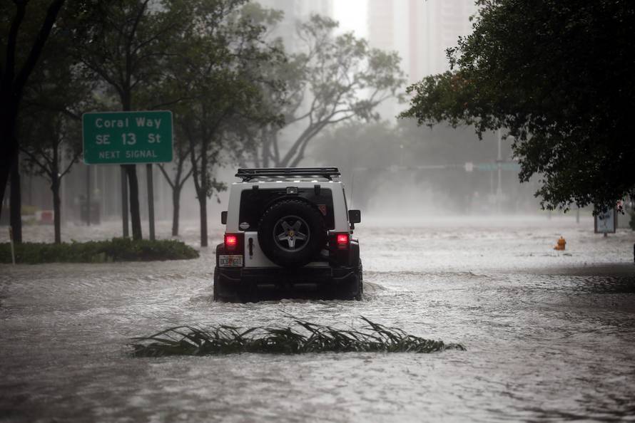 A vehicle drives along a flooded street in downtown Miami as Hurricane Irma arrives at south Florida
