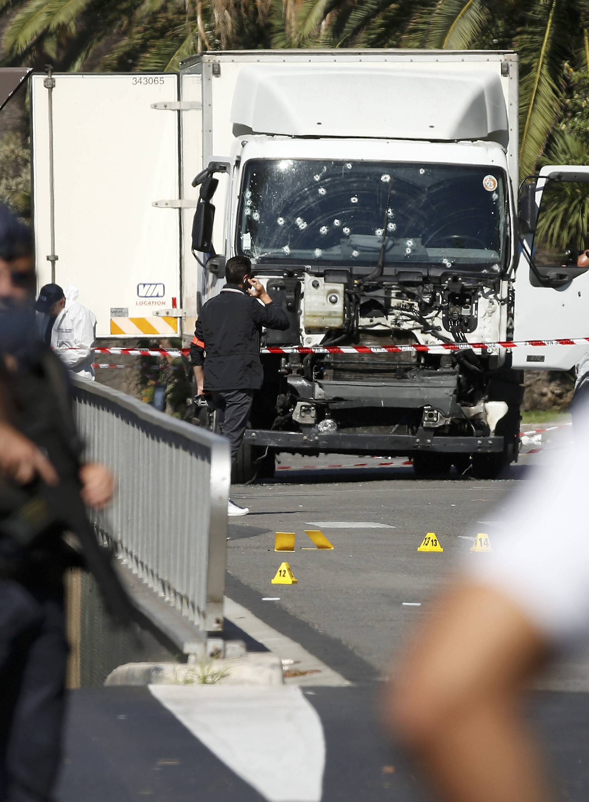 French police secure the area as the investigation continues at the scene near the heavy truck that ran into a crowd at high speed killing scores who were celebrating the Bastille Day July 14 national holiday on the Promenade des Anglais in Nice