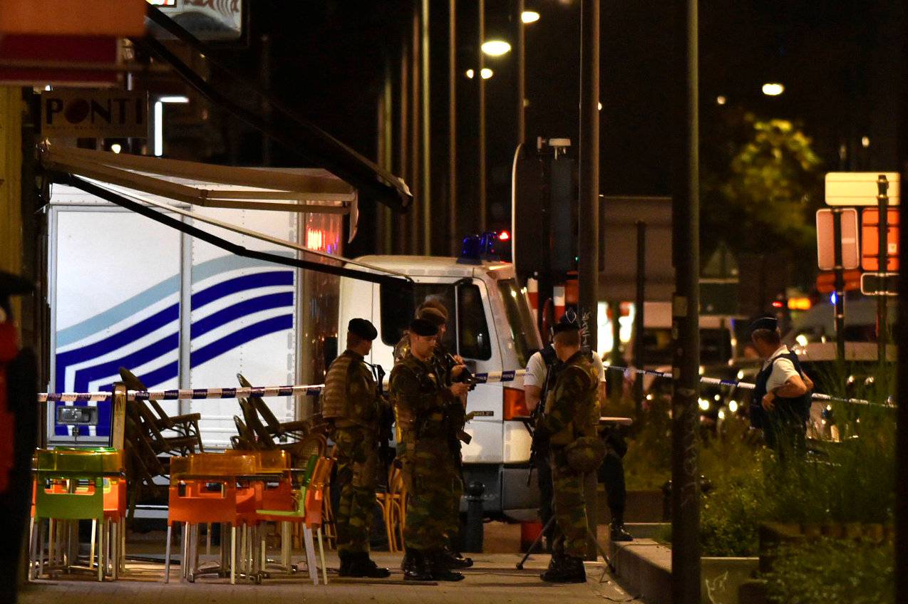 Policemen and Belgian soldiers react on the scene after Belgian soldiers shot a man who attacked them with a knife, in Brussels