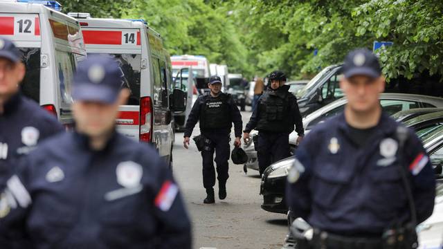 Police officers secure the area after a 14-year-old boy opened fire on other students and security guards at a school in downtown Belgrade