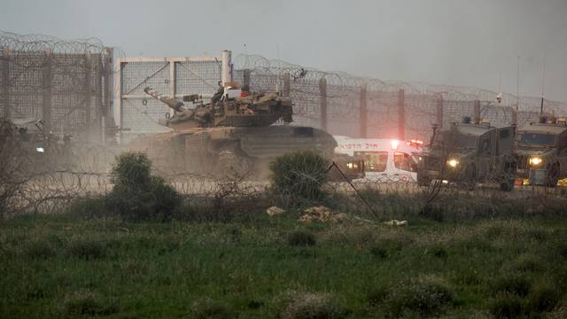 A tank manoeuvres along the Israel-Gaza border fence