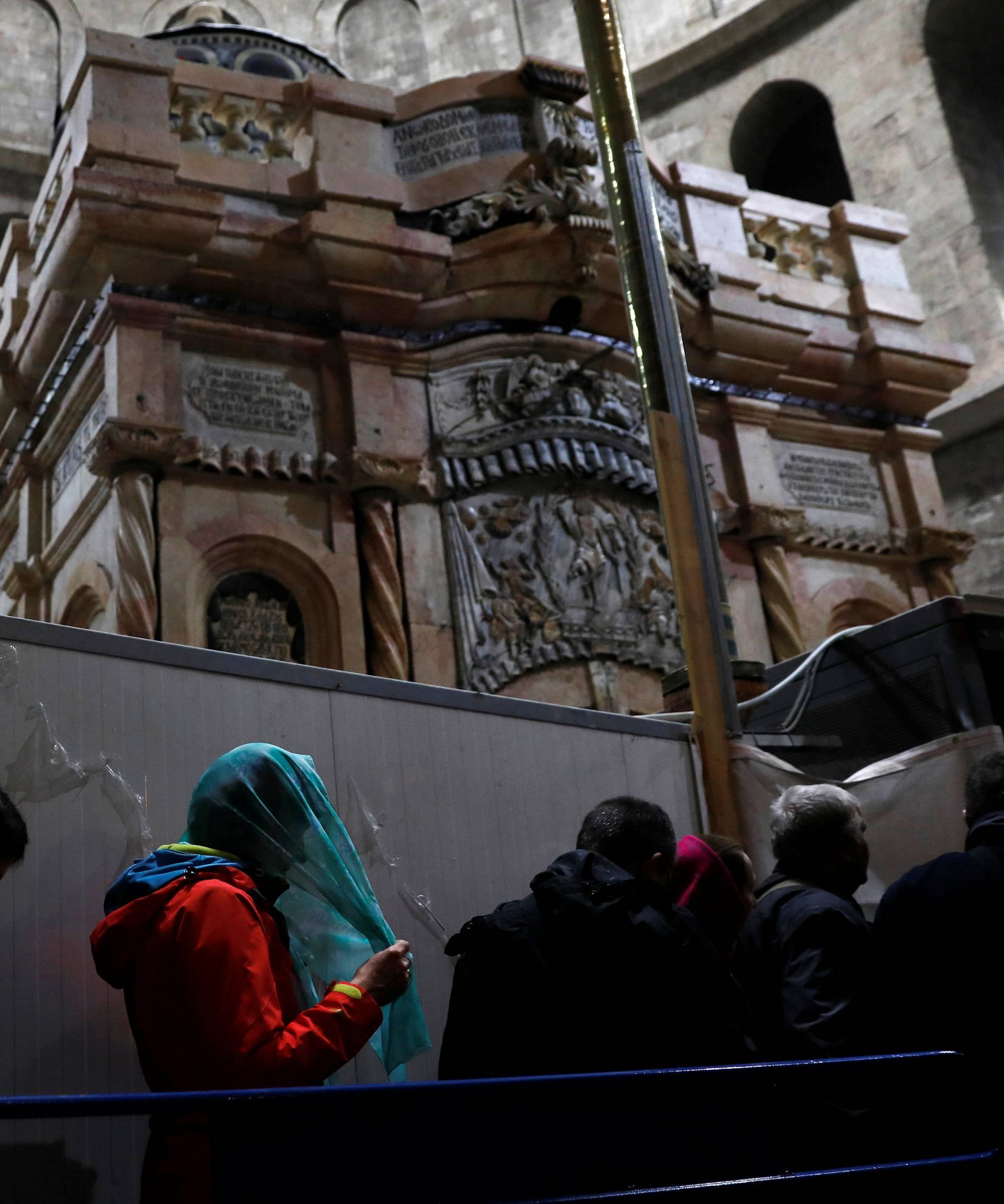 Visitors stand near the newly restored Edicule, the ancient structure housing the tomb, which according to Christian belief is where Jesus's body was anointed and buried, at the Church of the Holy Sepulchre in Jerusalem's Old City