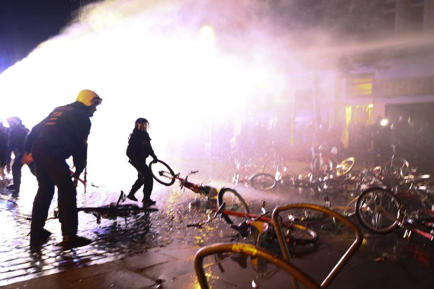 Riot police officer pulls a bicycle that protesters used as a barricade during demonstrations at the G20 summit in Hamburg