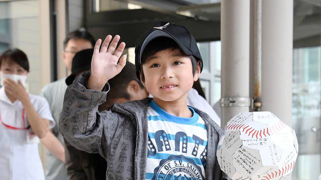 Yamato Tanooka, who was found by authorities in the woods nearly a week after his parents abandoned him for disciplinary reasons, waves as he leaves a hospital in Hakodate