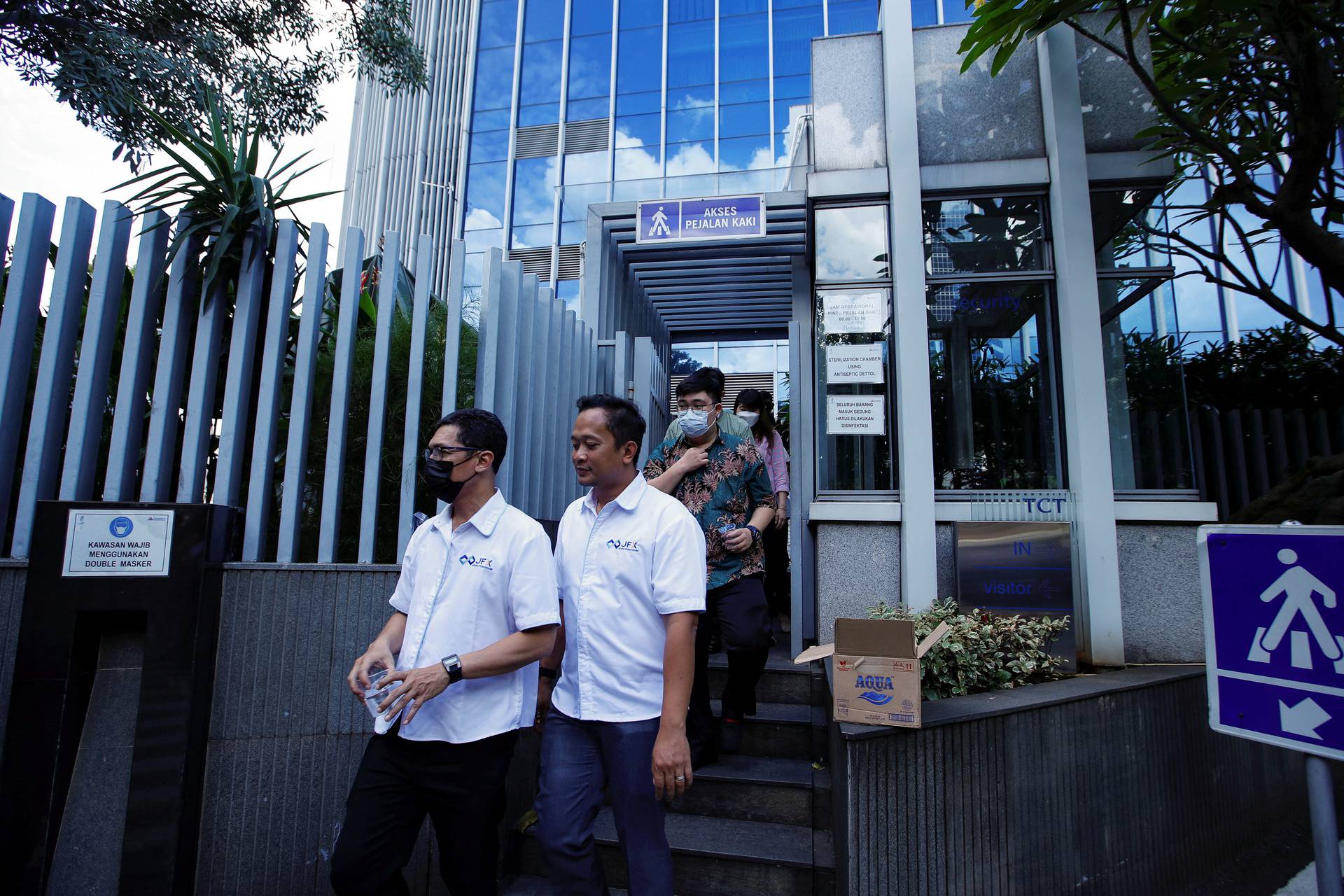 People gather as they are evacuated outside a building following an earthquake in Jakarta