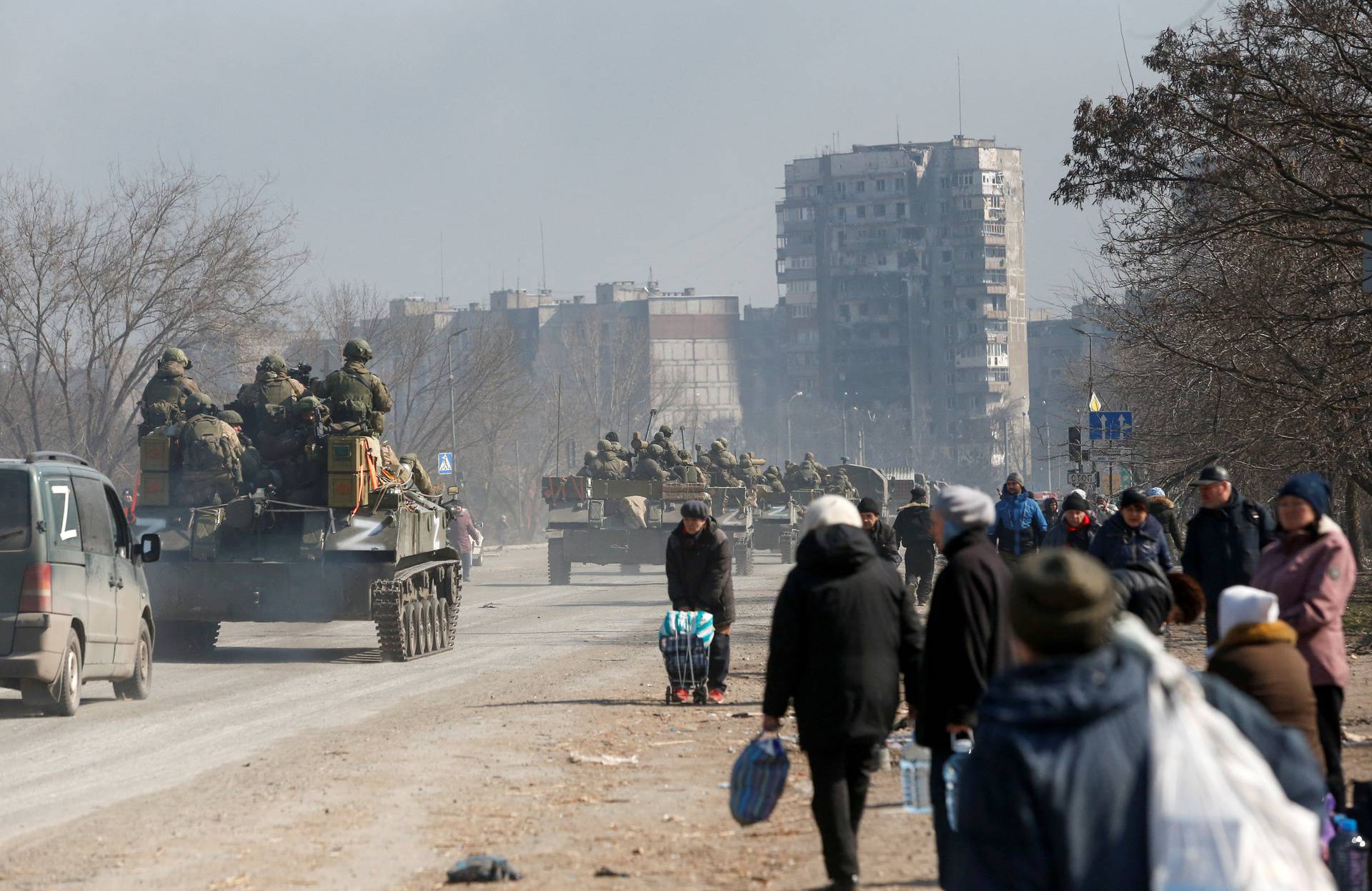 Service members of pro-Russian troops are seen atop of armoured vehicles in the besieged city of Mariupol