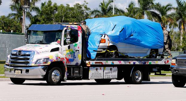 A white van seized during an investigation into a series of parcel bombs is towed into FBI headquarters in Miramar