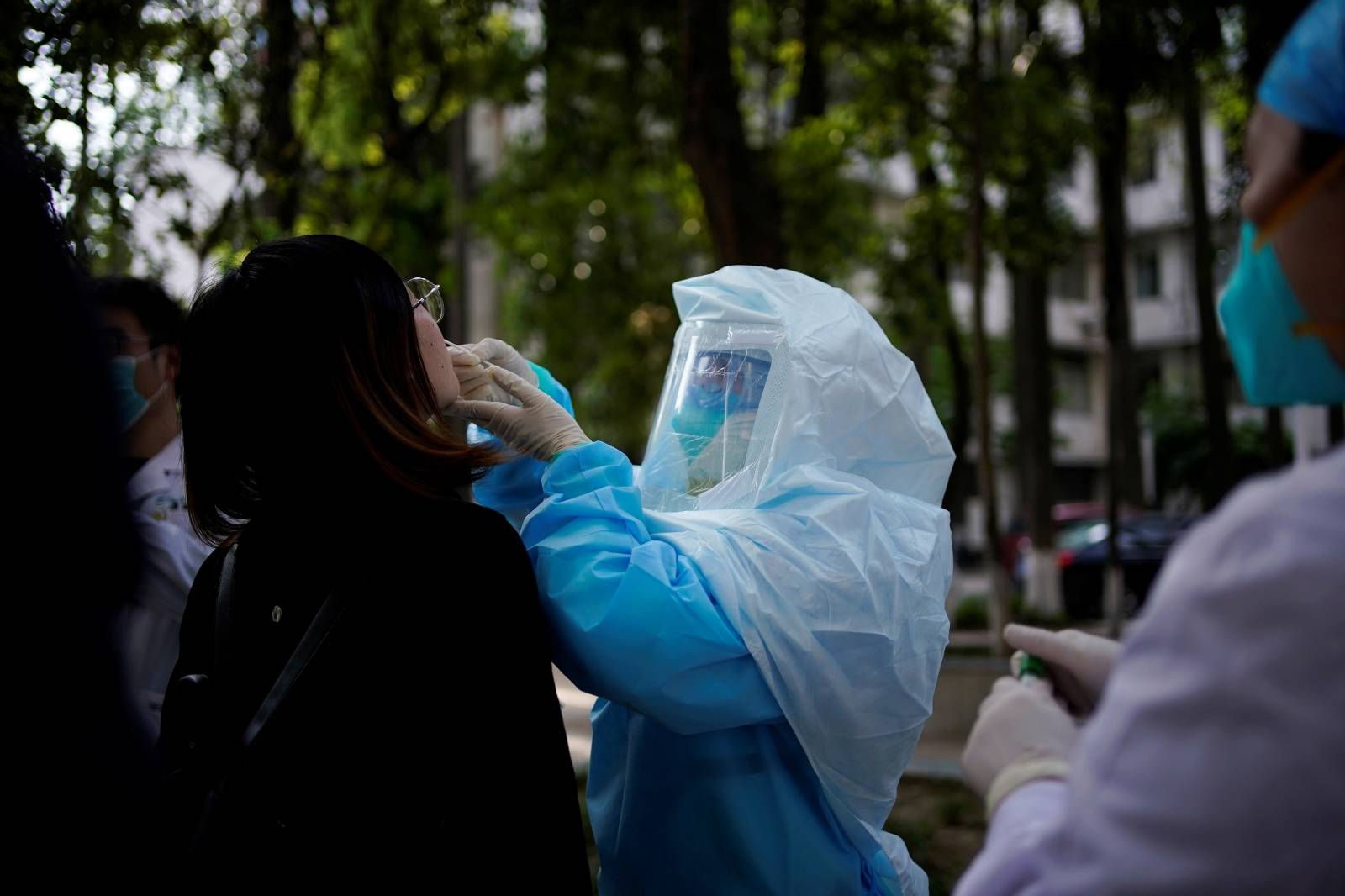 A woman receives a nucleic acid test for COVID-19 on a street near a hospital after the lockdown was lifted in Wuhan