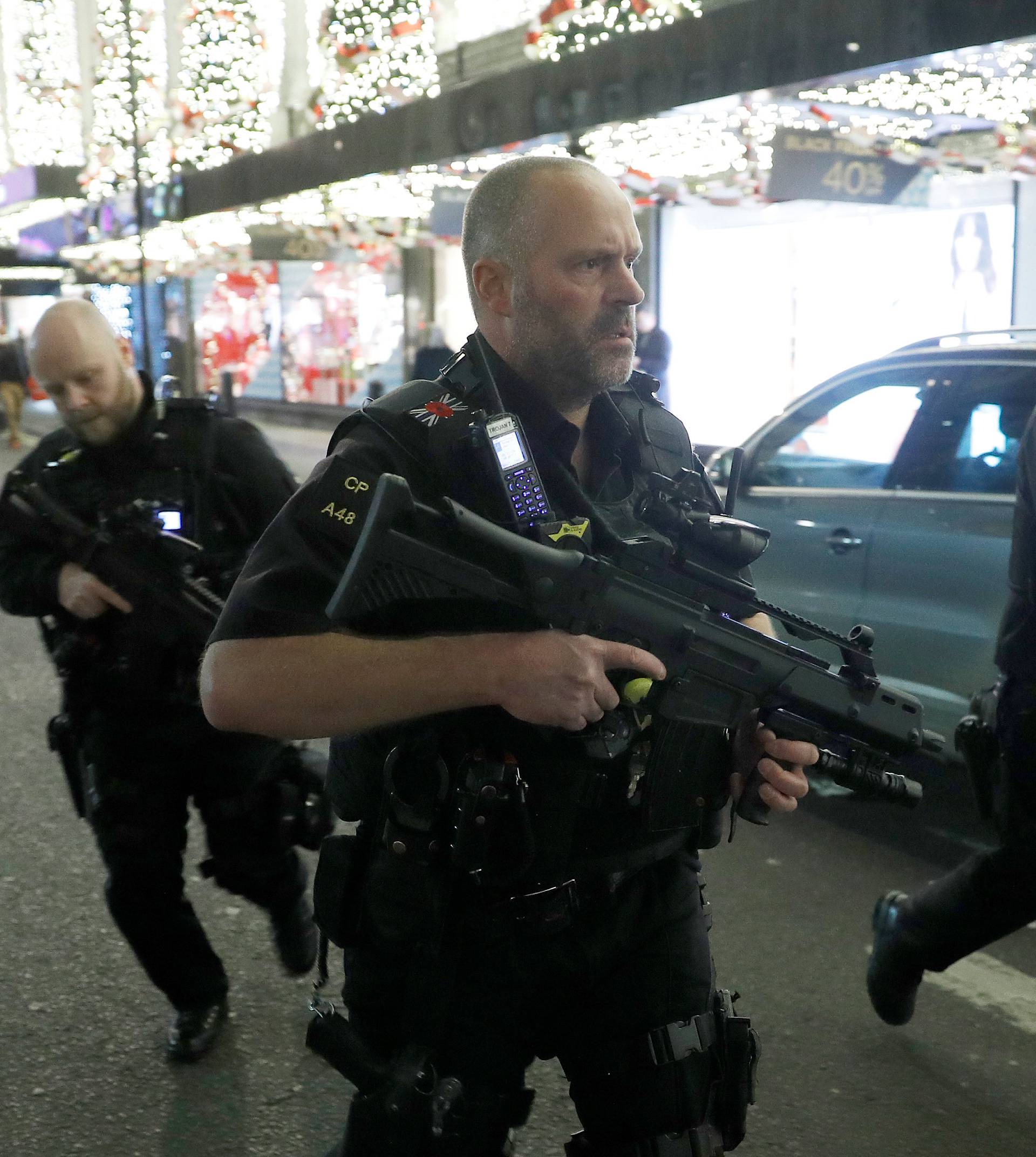 Armed police run along Oxford Street, London