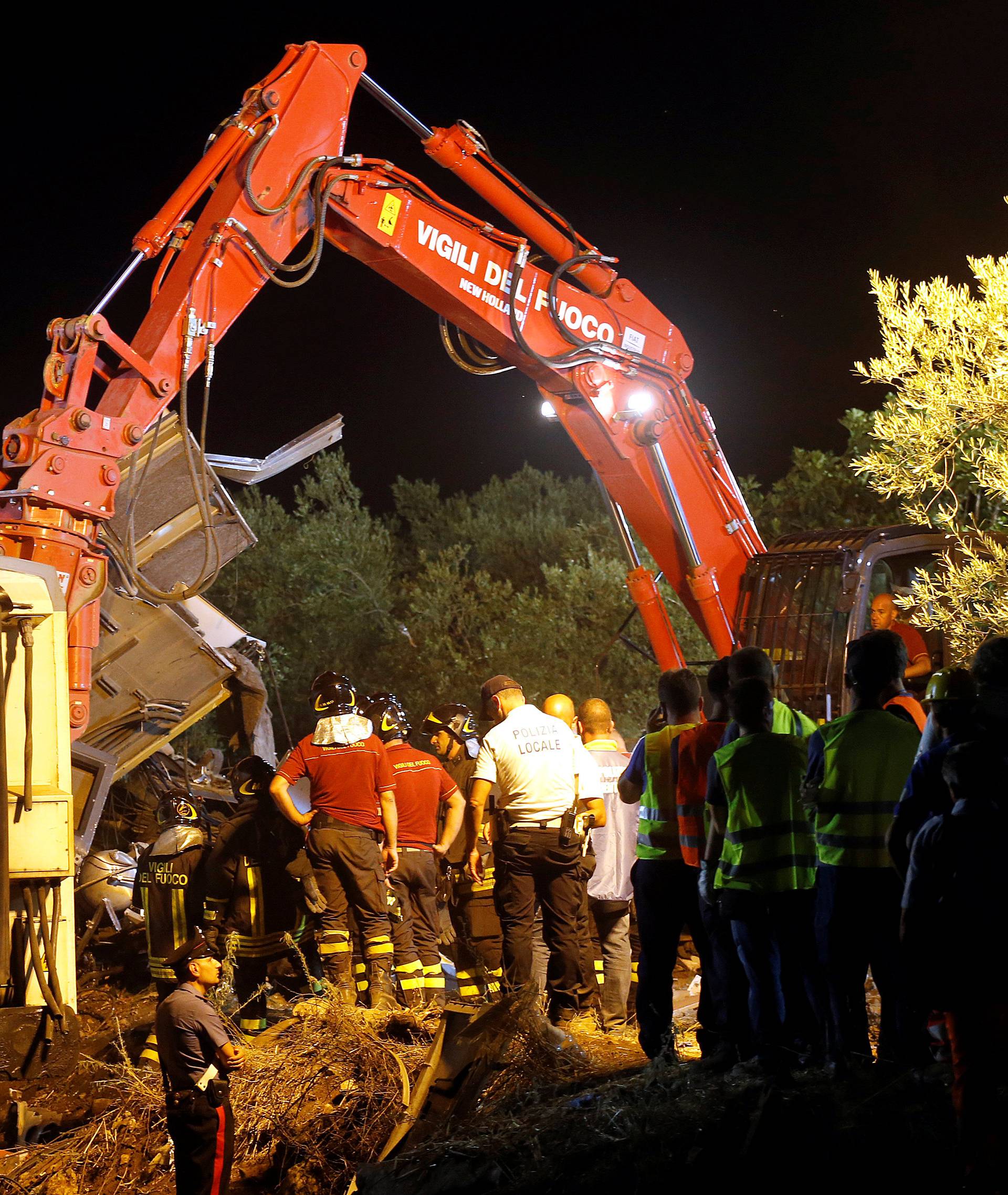 Rescuers work at the site where two passenger trains collided in the middle of an olive grove in the southern village of Corato