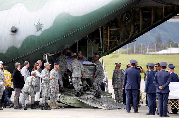 Military personnel unload a coffin with the remains of Brazilian victims who died in an accident of the plane that crashed into the Colombian jungle, at the airport from where the bodies will be flown home to Brazil, in Medellin