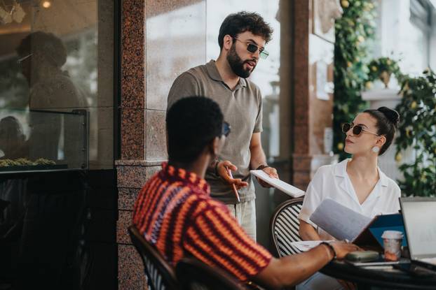 Business partners discussing new project in modern coffee shop, planning and strategizing