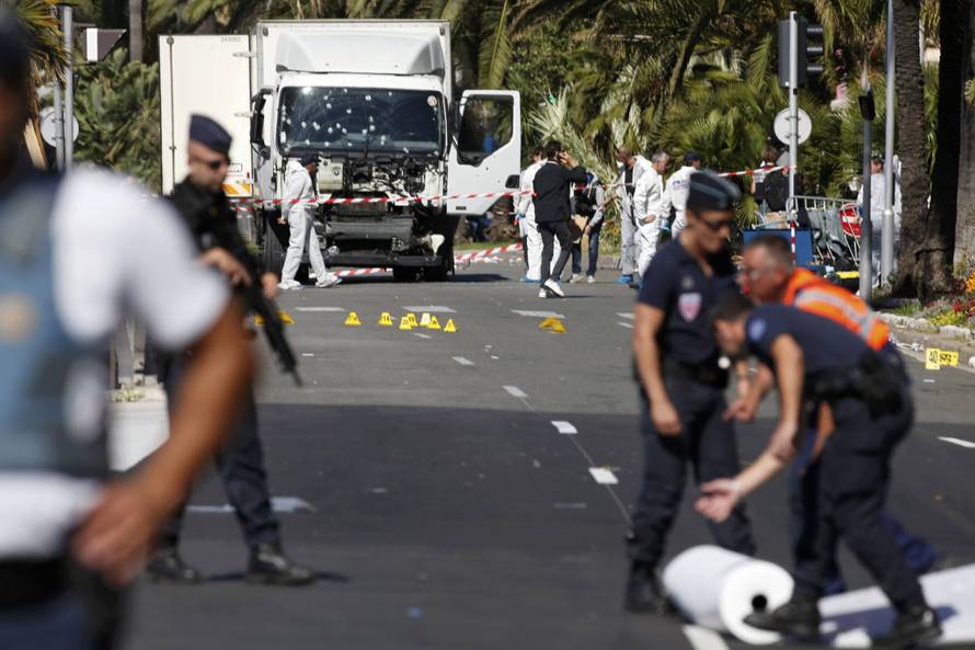 French police secure the area as the investigation continues at the scene near the heavy truck that ran into a crowd at high speed killing scores who were celebrating the Bastille Day July 14 national holiday on the Promenade des Anglais in Nice