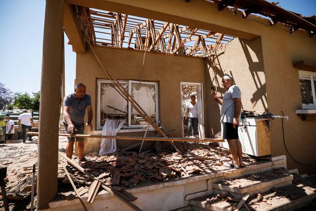 Rachel and Yehushua El-Gazar check their house that was damaged following a rocket fire from Gaza towards Israel, in Sderot