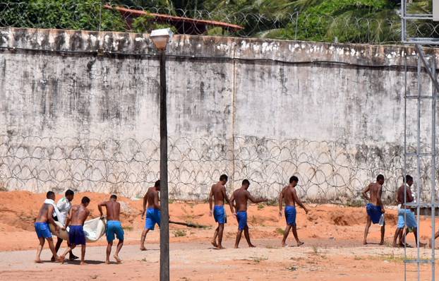 Inmates carry bodies after a prison riot in Natal