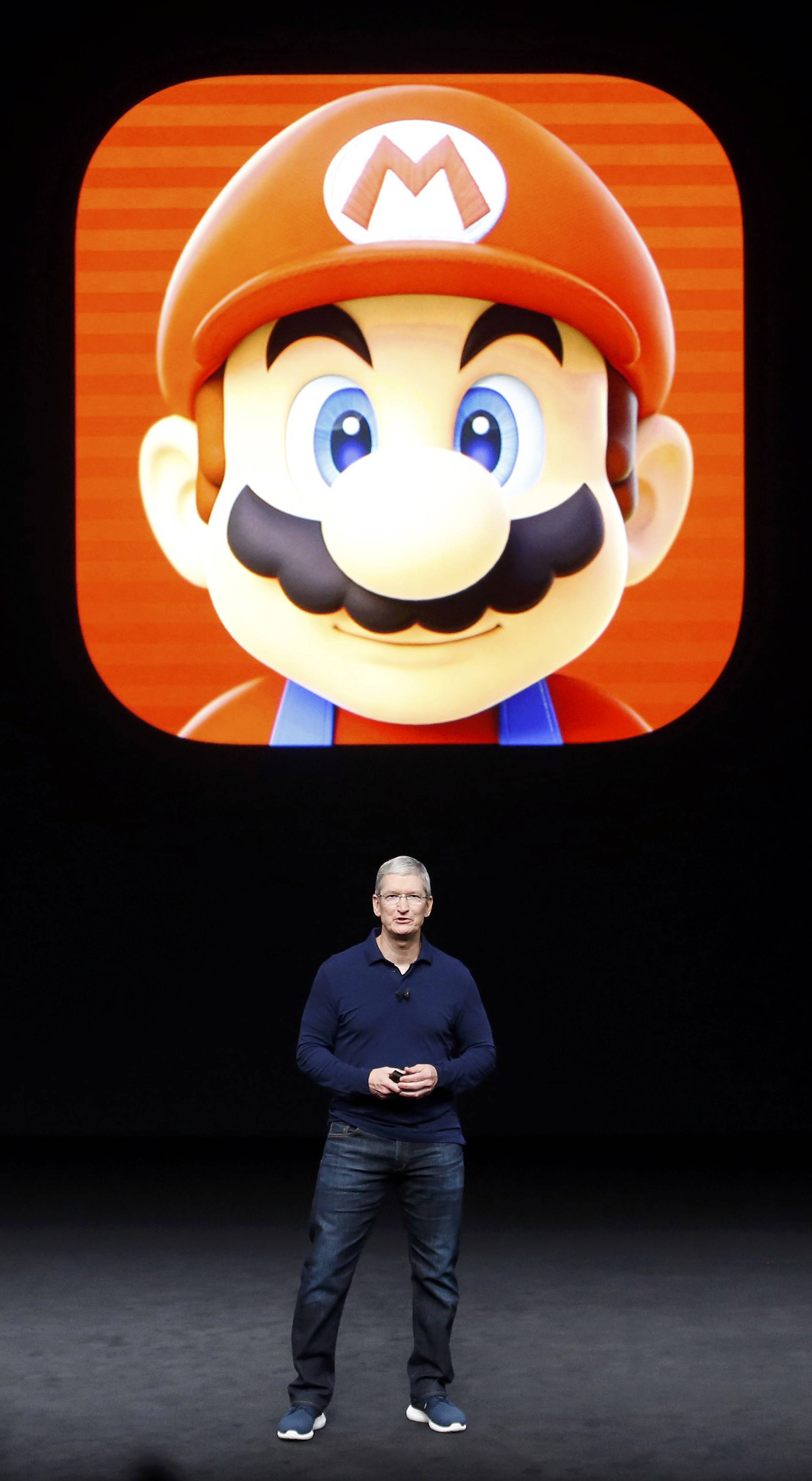 Tim Cook speaks in front of a Mario Bros. image during an Apple media event in San Francisco
