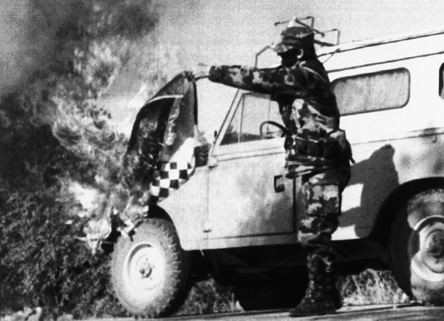 Serbian soldier burns a Croatian flag
