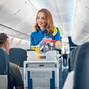 Flight attendant serving food and drinks to passengers on board