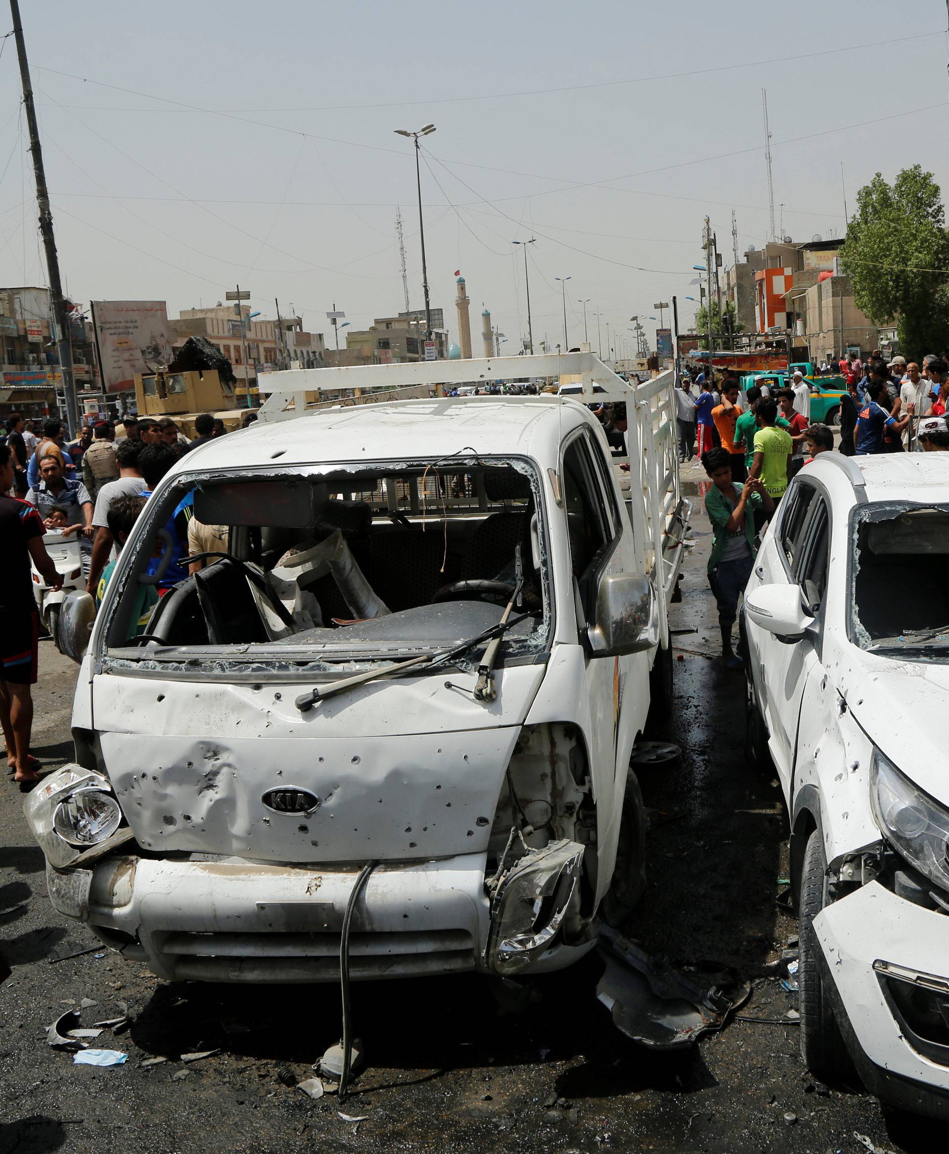 People gather at the scene of a car bomb attack in Baghdad's mainly Shi'ite district of Sadr City