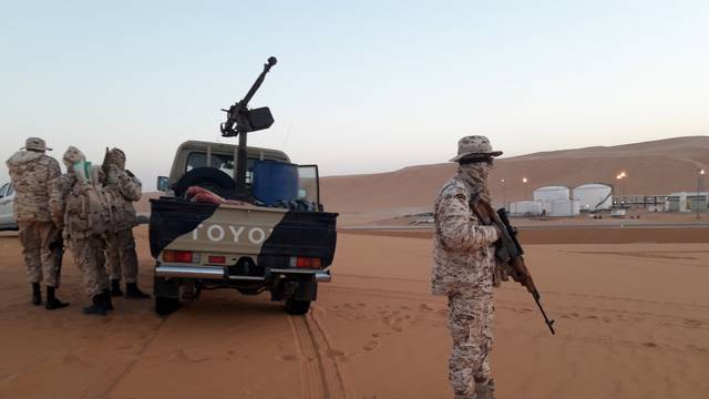 Members of forces loyal to Libyan military commander Khalifa Haftar guard near Libya's El Sharara oilfield  in Obari