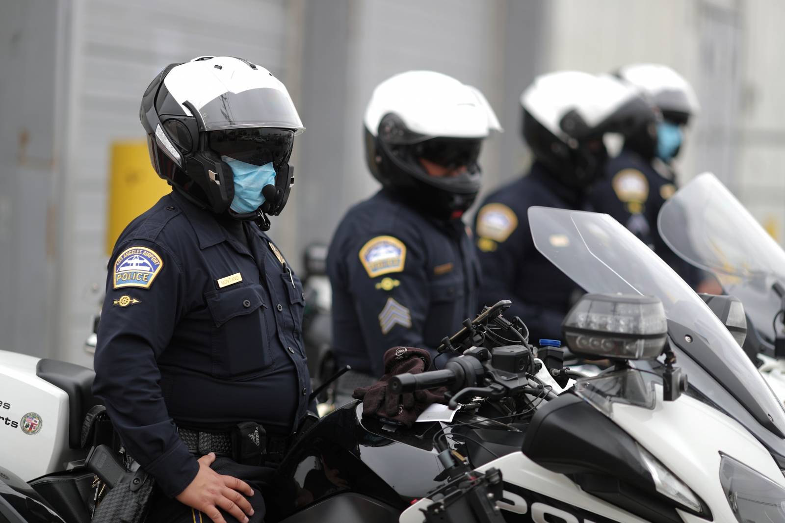 California Highway Patrol police officers wear masks as they watch hotel workers protesting outside airport hotels to demand healthcare coverage extension as the global outbreak of the coronavirus disease (COVID-19) continues, in Los Angeles