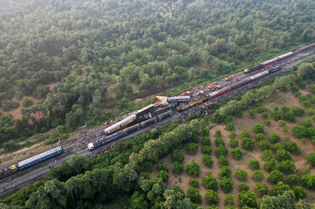 A drone view shows heavy machinery removing damaged coaches following a collision between two passenger trains in Vizianagaram