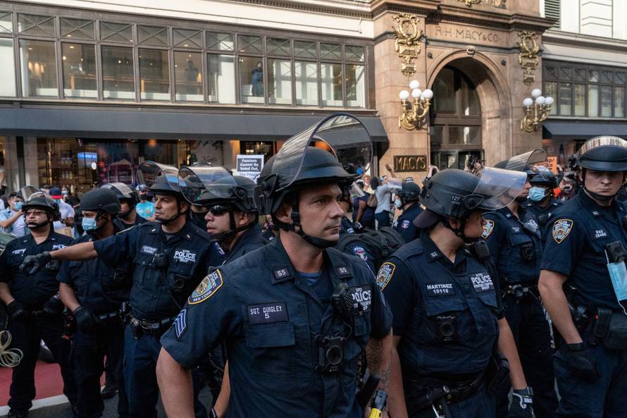 New York Police Department (NYPD) officers stand guard during a march demanding Donald Trump and Mike Pence leave office near Herald Square in the Manhattan borough of New York City