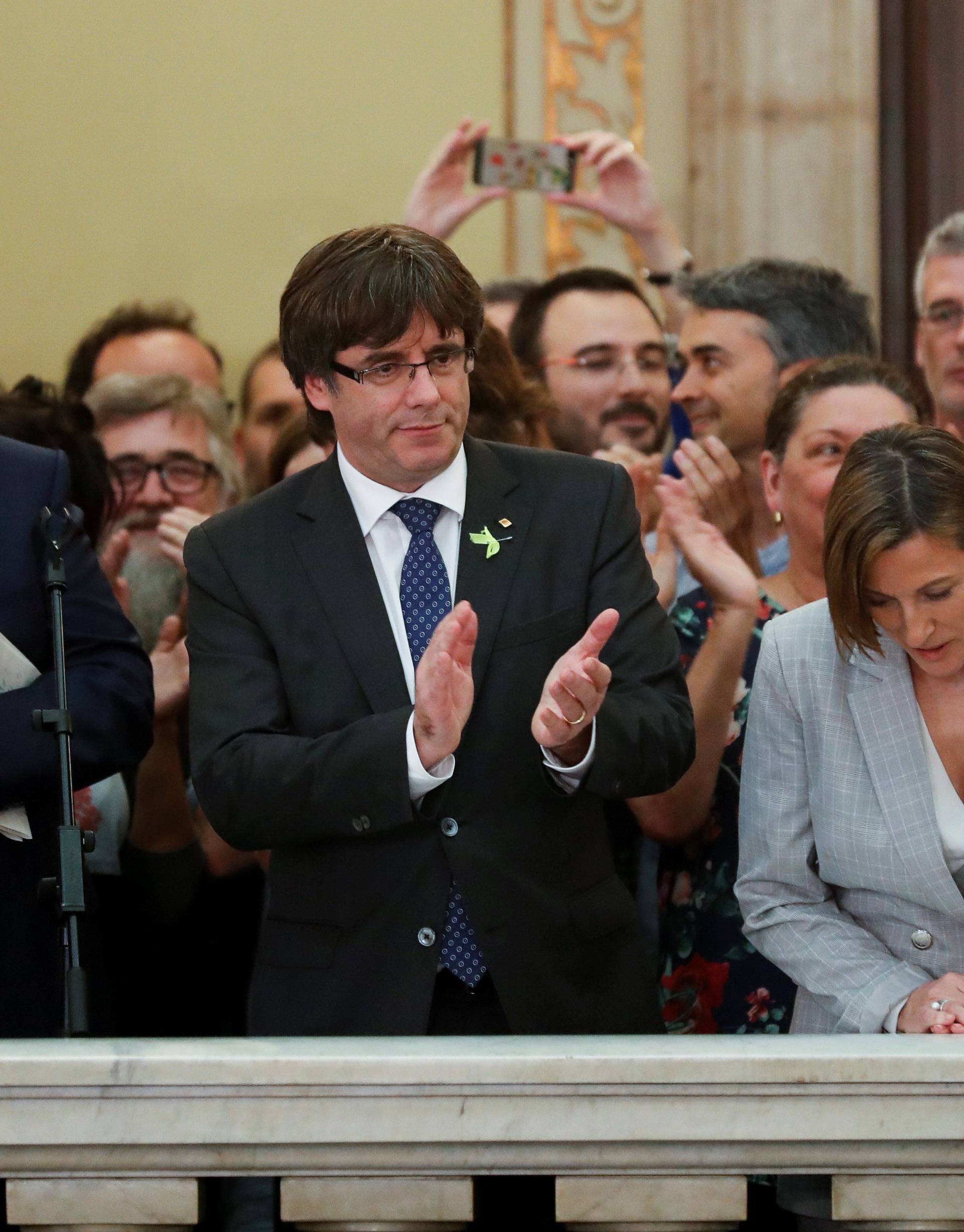 Catalan President Carles Puigdemont applauds after the Catalan regional Parliament declared independence from Spain in Barcelona