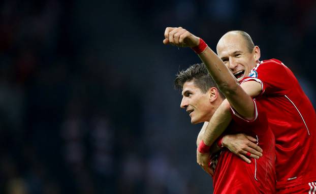 FILE PHOTO: Bayern Munich striker Mario Gomez celebrates with Arjen Robben after scoring against VfB Stuttgart in the German Cup final at the Olympic Stadium in Berlin.