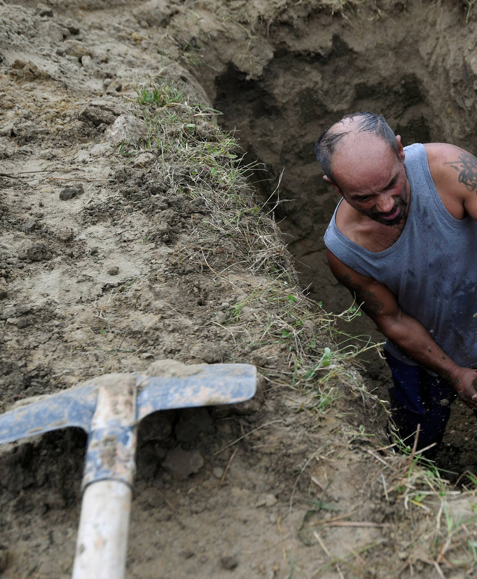 A gravedigger competes in a grave digging championship in Trencin, Slovakia