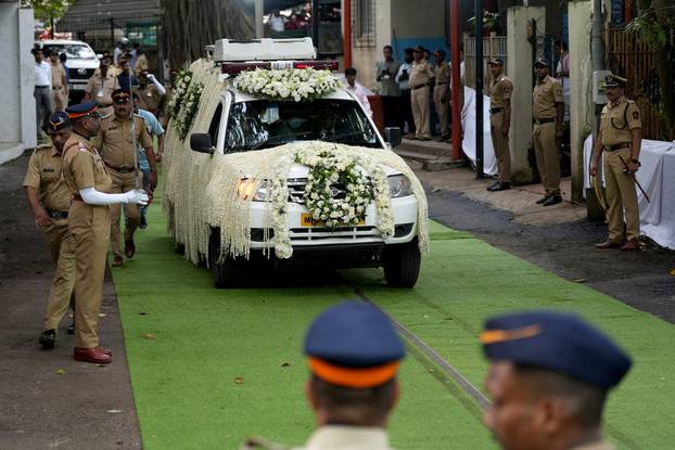 A hearse van carrying the body of former chairman of Tata Group Ratan Tata, moves past police officers on the day of his funeral in Mumbai