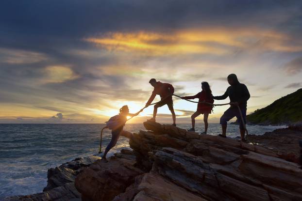 Silhouette,Male,And,Female,Hikers,Climbing,Up,Mountain,Cliff,.