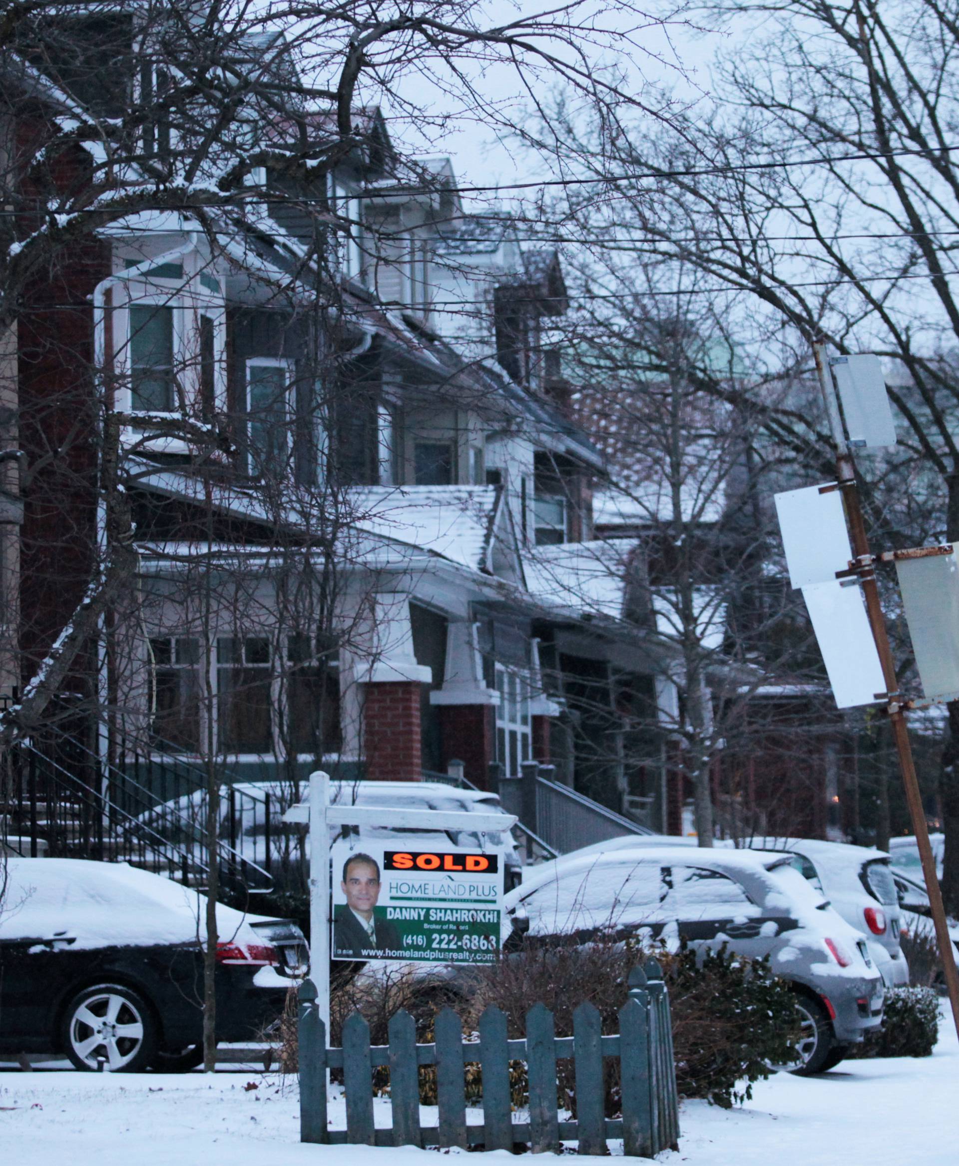 House sold sign is seen after an overnight snow storm, in Toronto