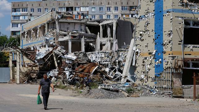 A man walks past a destroyed building in Mariupol
