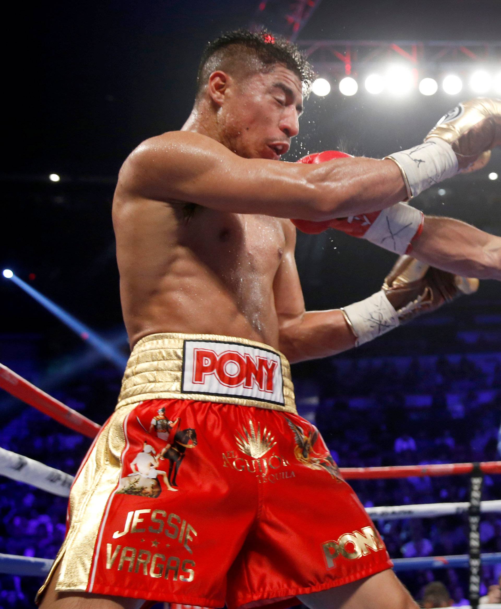WBO welterweight champion Jessie Vargas (L) of Las Vegas gets hit with a punch from Manny Pacquiao of the Philippines during their title fight at the Thomas & Mack Center in Las Vegas