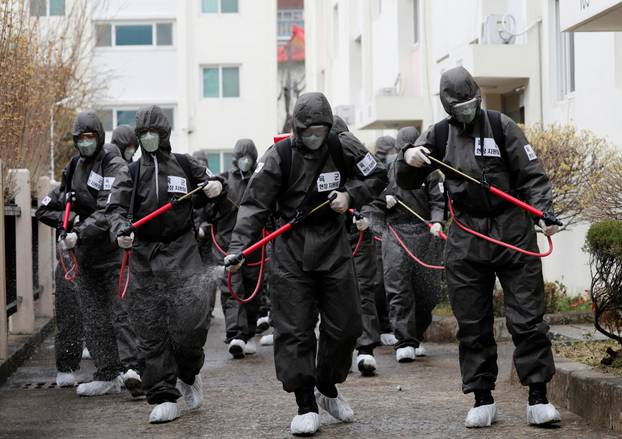 South Korean soldiers spray disinfectants inside an apartment complex which is under cohort isolation after mass infection of coronavirus disease (COVID-19) in Daegu