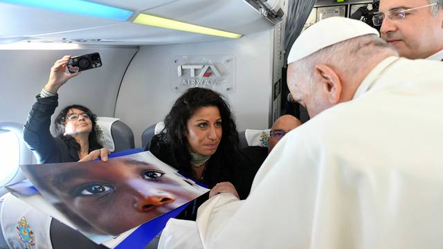 Reuters photographer Yara Nardi shows Pope Francis her photo of a child taken on the Sicilian island of Lampedusa