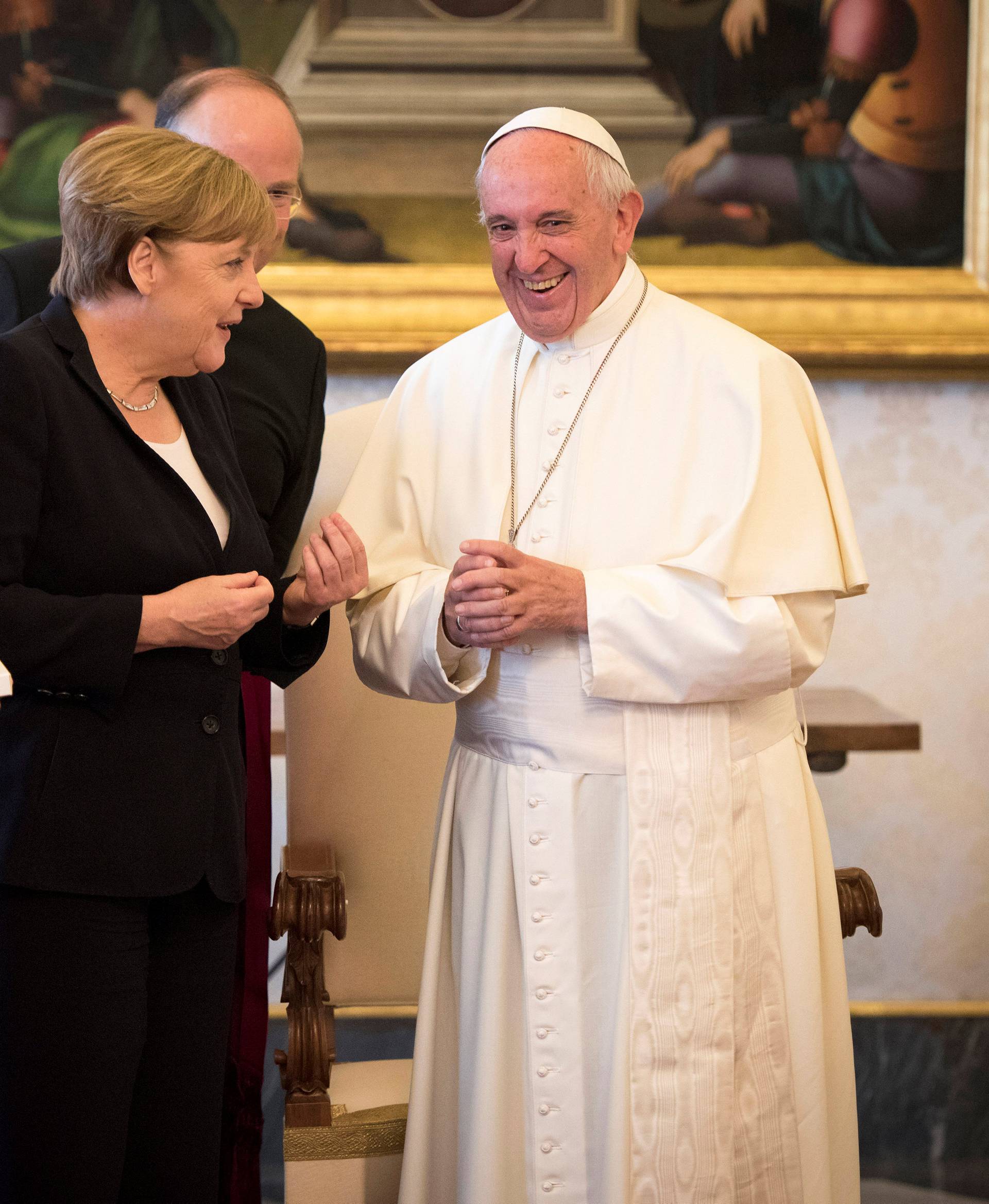German Chancellor Angela Merkel and her husband Joachim Sauer talk with Pope Francis during a meeting at the Vatican