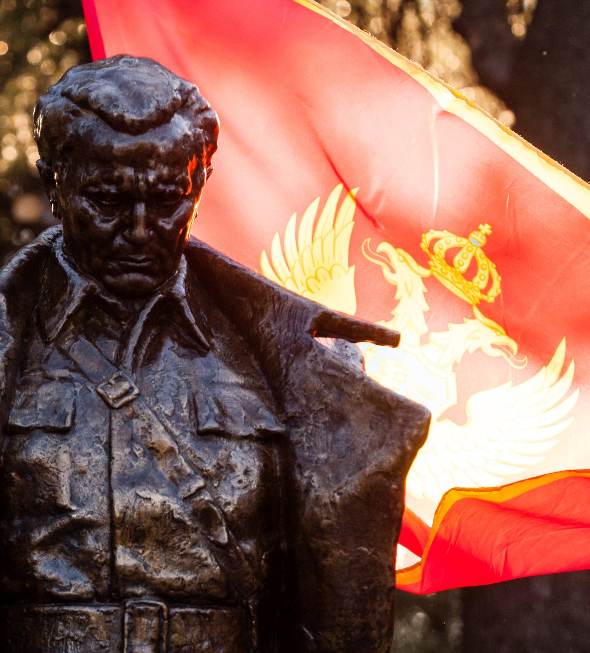 Montenegrian flag wave behind the monument of late Yugoslav leader Josip Broz Tito after unveiling ceremony in Podgorica