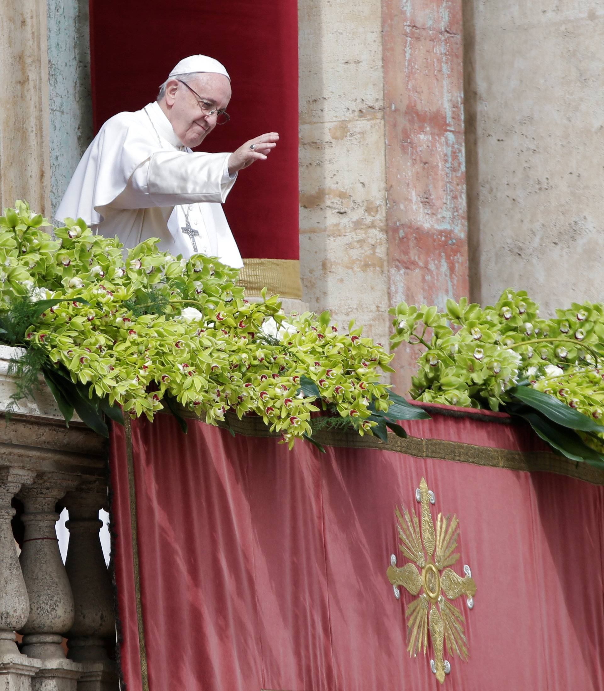 Pope Francis waves after delivering his Easter message in the Urbi et Orbi (to the city and the world) address from the balcony overlooking St. Peter's Square at the Vatican