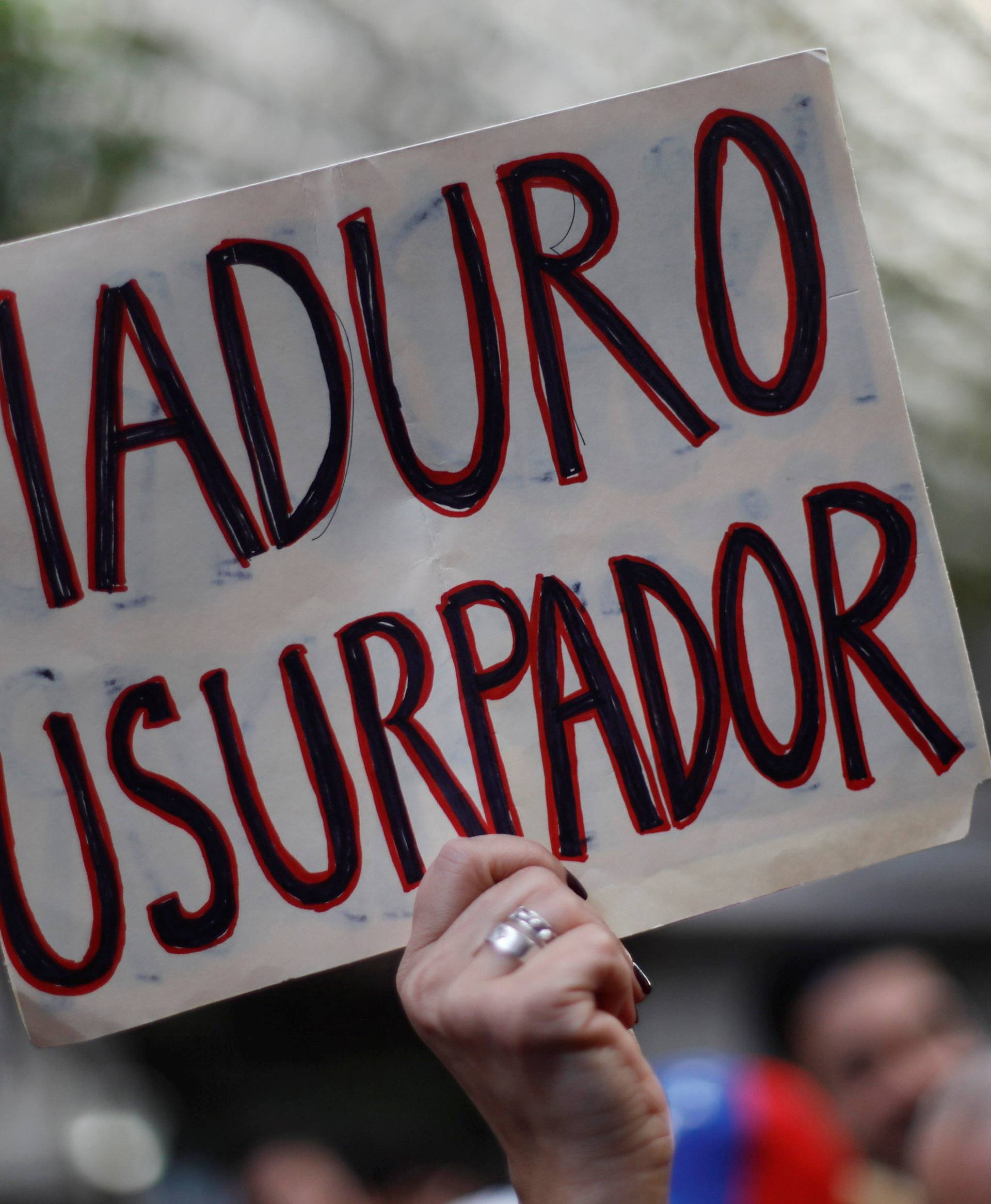 A woman holds a sign as she gathers in support of Venezuela's opposition leader Juan Guaido outside the Embassy of Venezuela in Mexico City